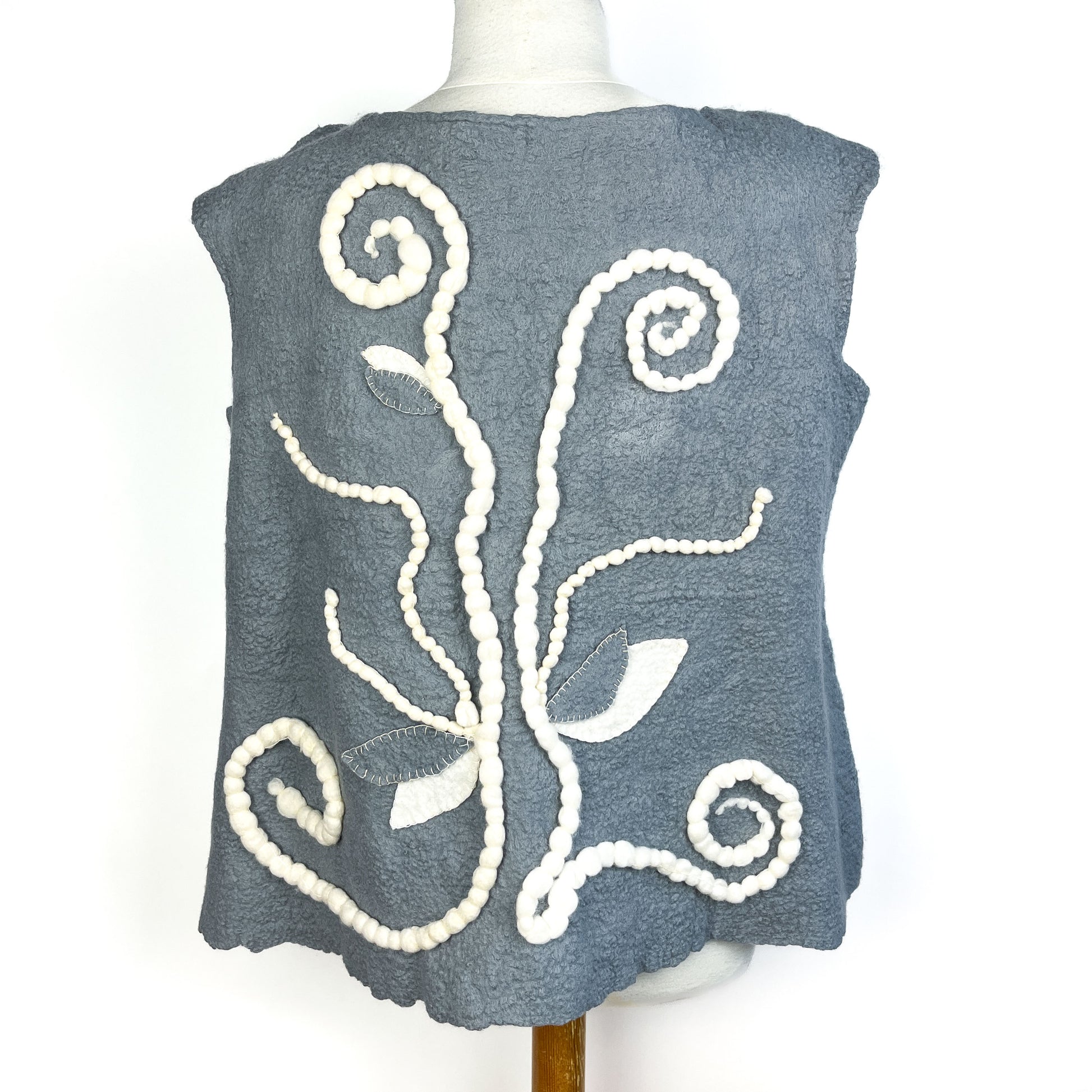 Back view of a gray Merino Wool Vest featuring a decorative cotton yarn design.