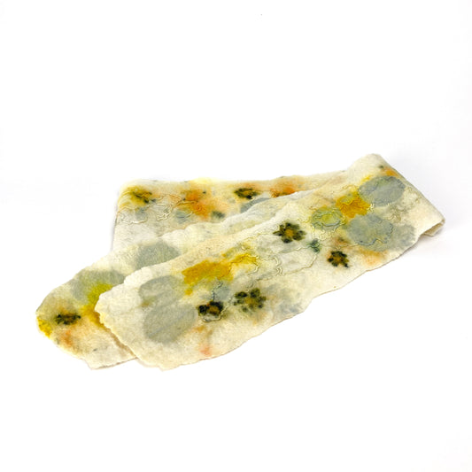 A soft, off-white Eco Print Scarf with abstract botanical patterns in muted yellows, greens, and grays.