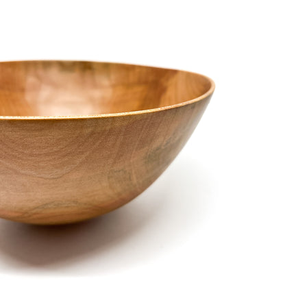 Angled view of a handcrafted Pink Dogwood Bowl, highlighting its curves.