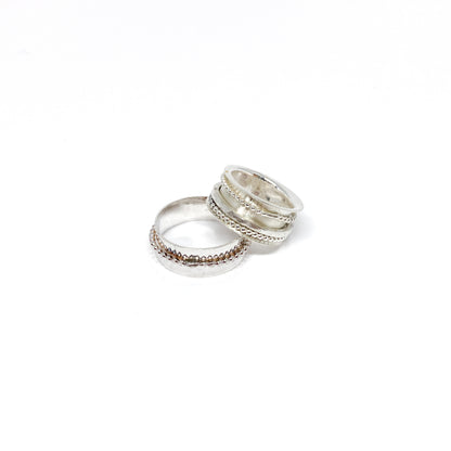 Two sterling silver spinner rings, one stacked, with beaded and textured spinning bands.