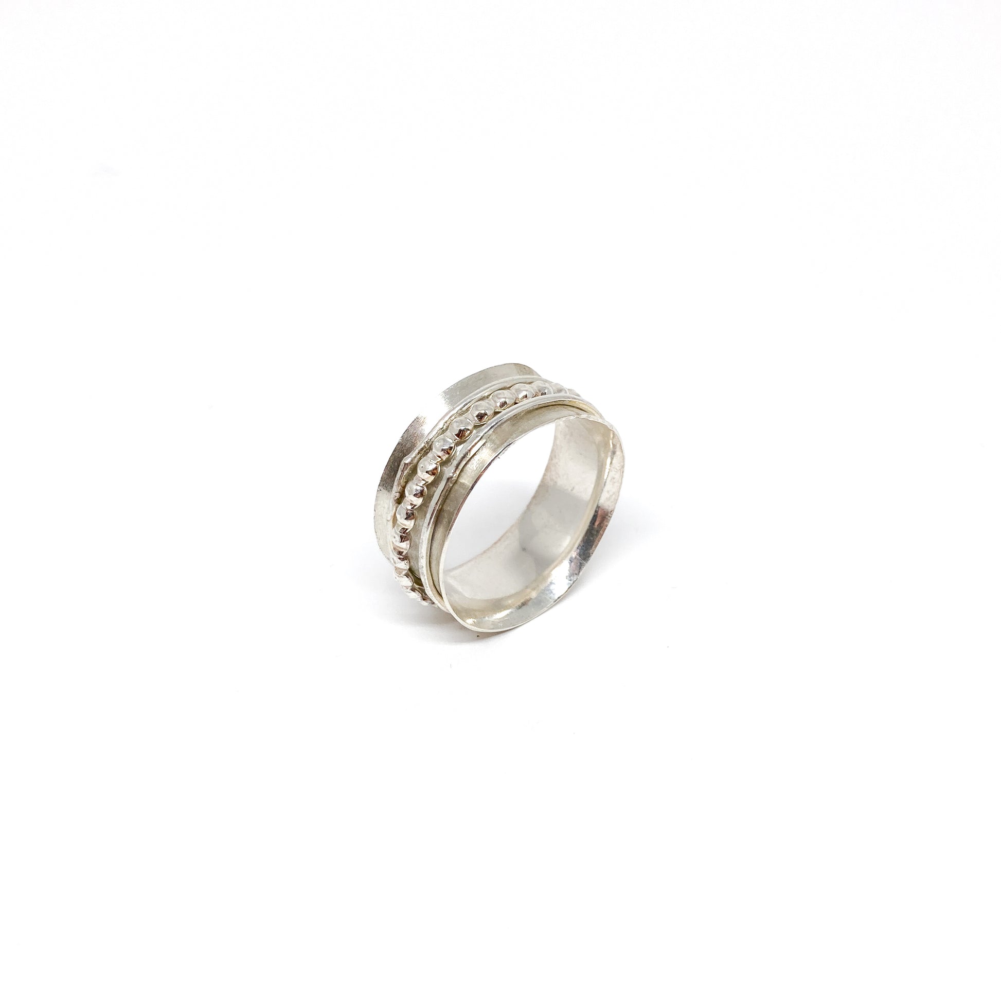 Silver spinner ring with multiple textured spinning bands, including a beaded row.