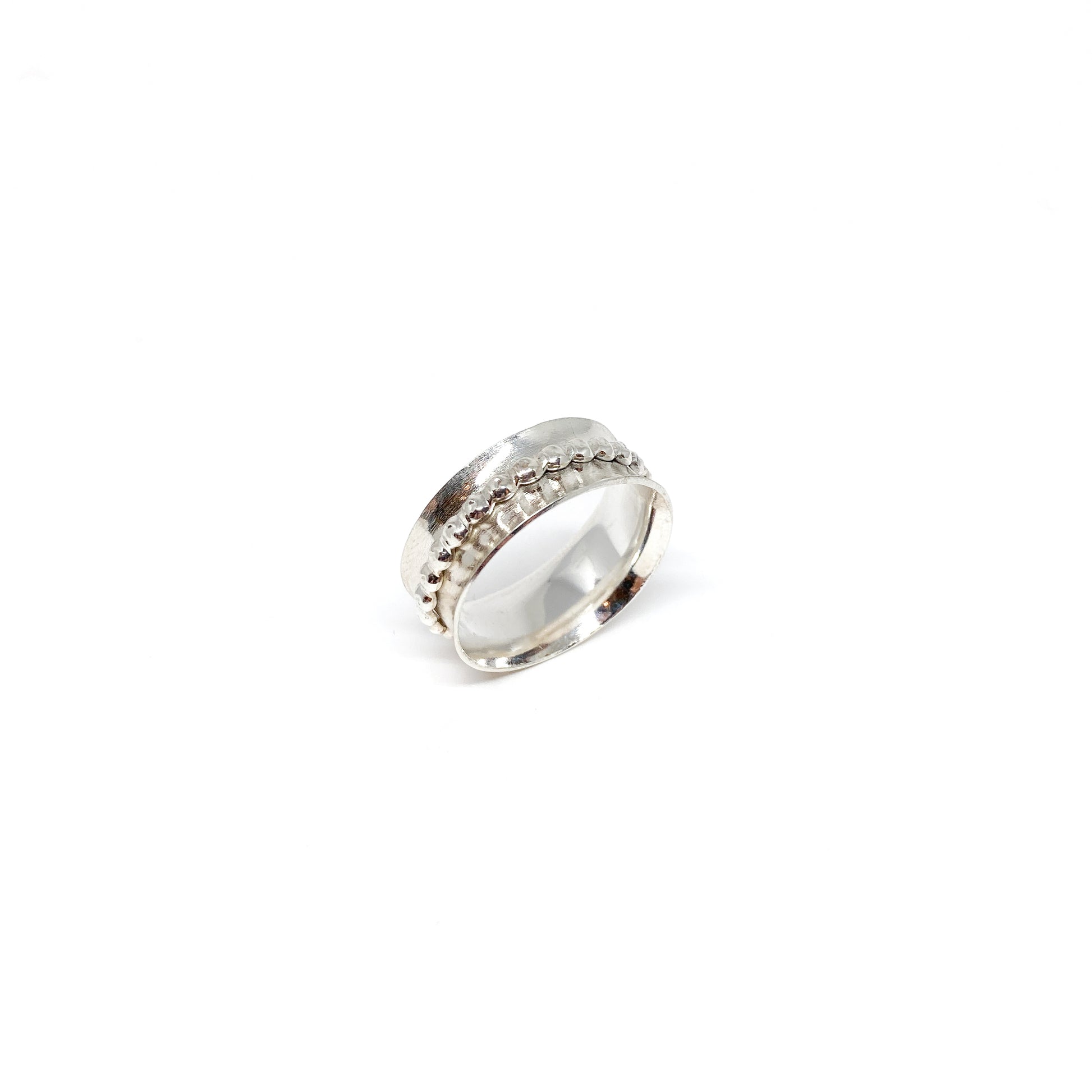 Silver spinner ring with a textured spinning band featuring rows of small dots.