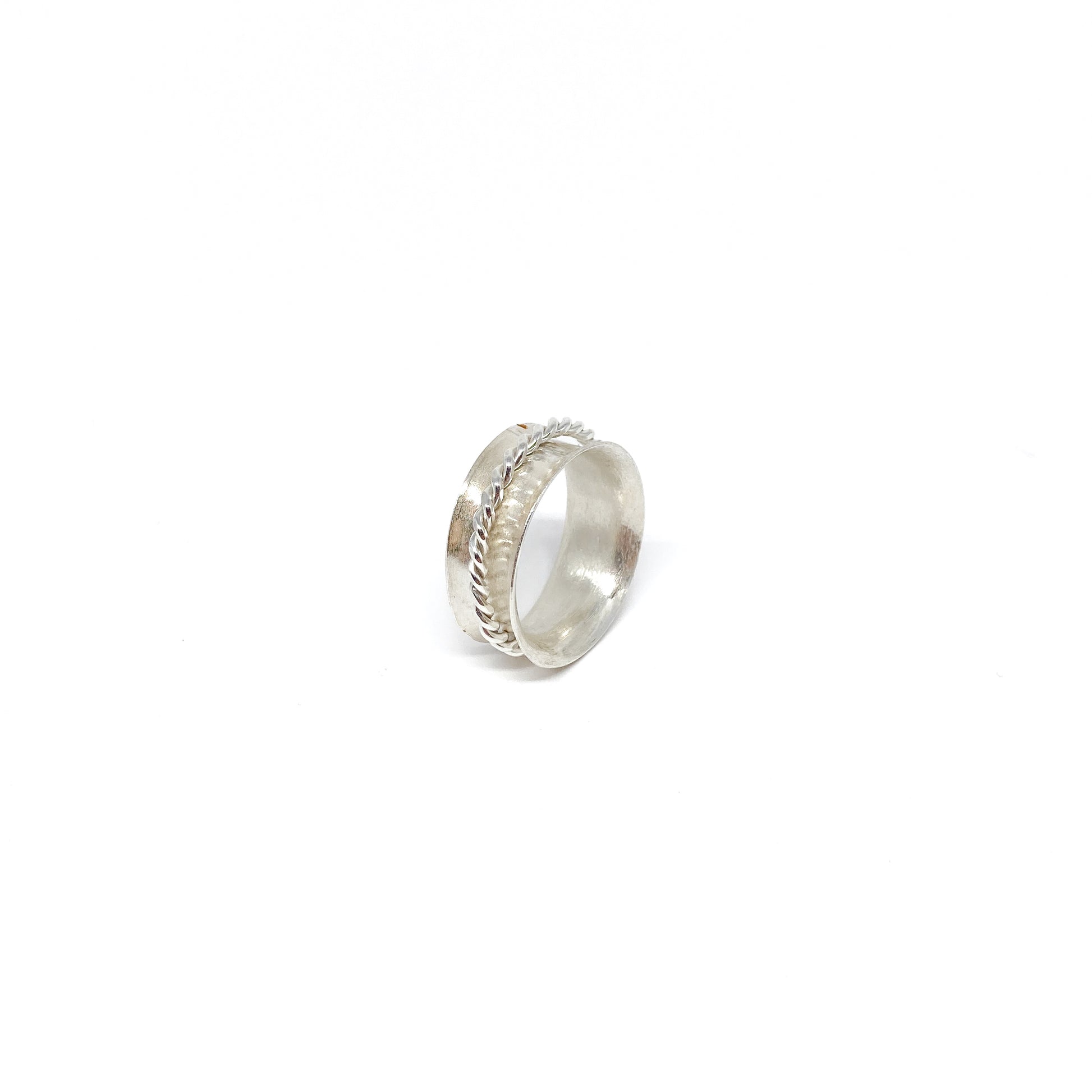 Silver spinner ring featuring a textured band and a delicate braided detail.