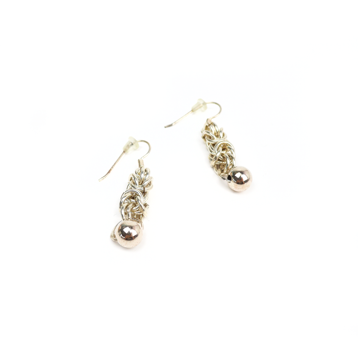 Angled view of King Chain Dangle Earrings with polished silver balls and complex chainmail links.