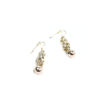 Angled view of King Chain Dangle Earrings with polished silver balls and complex chainmail links.