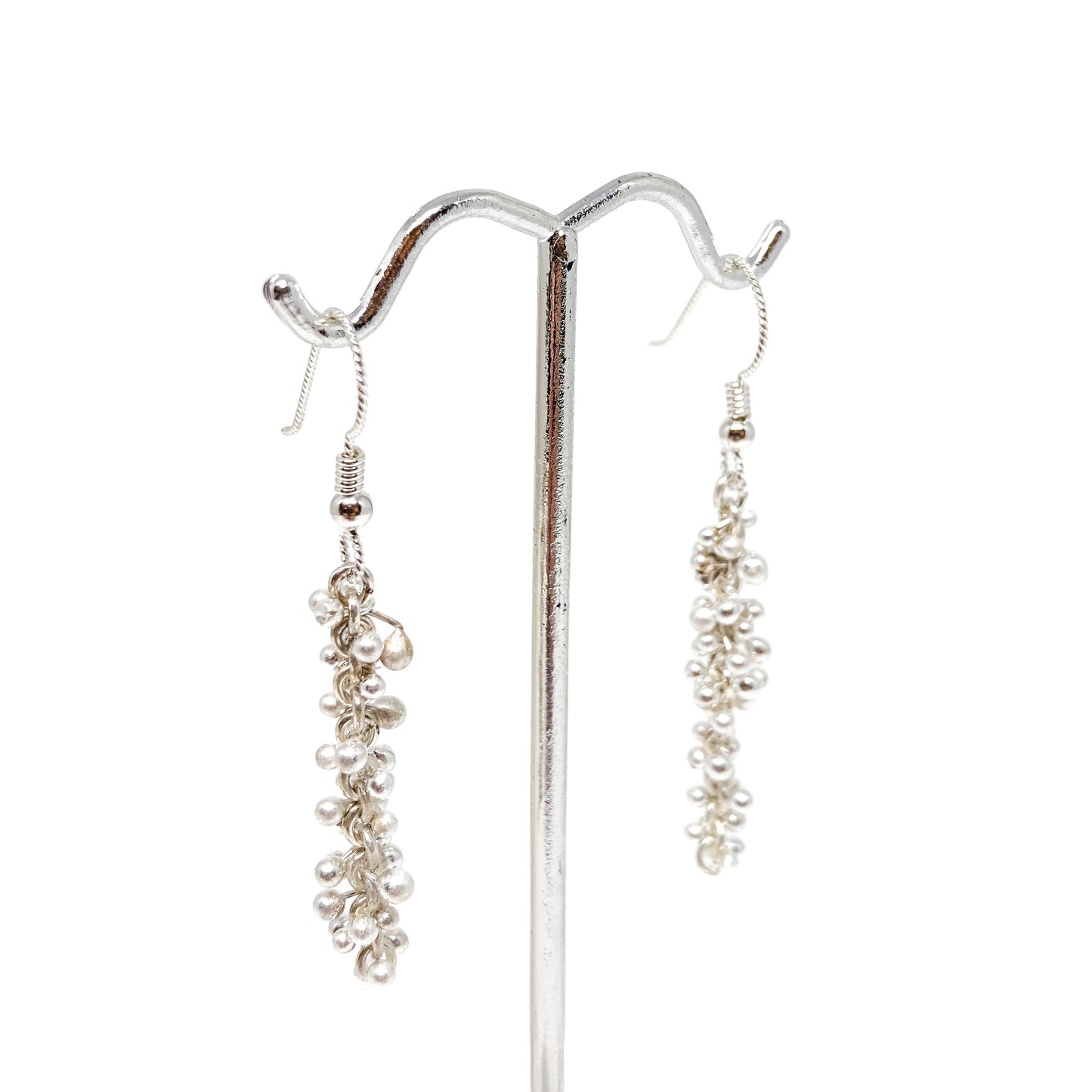 Side view of Baby Barbell Dangle Earrings hanging from a display stand, showcasing silver ball accents.