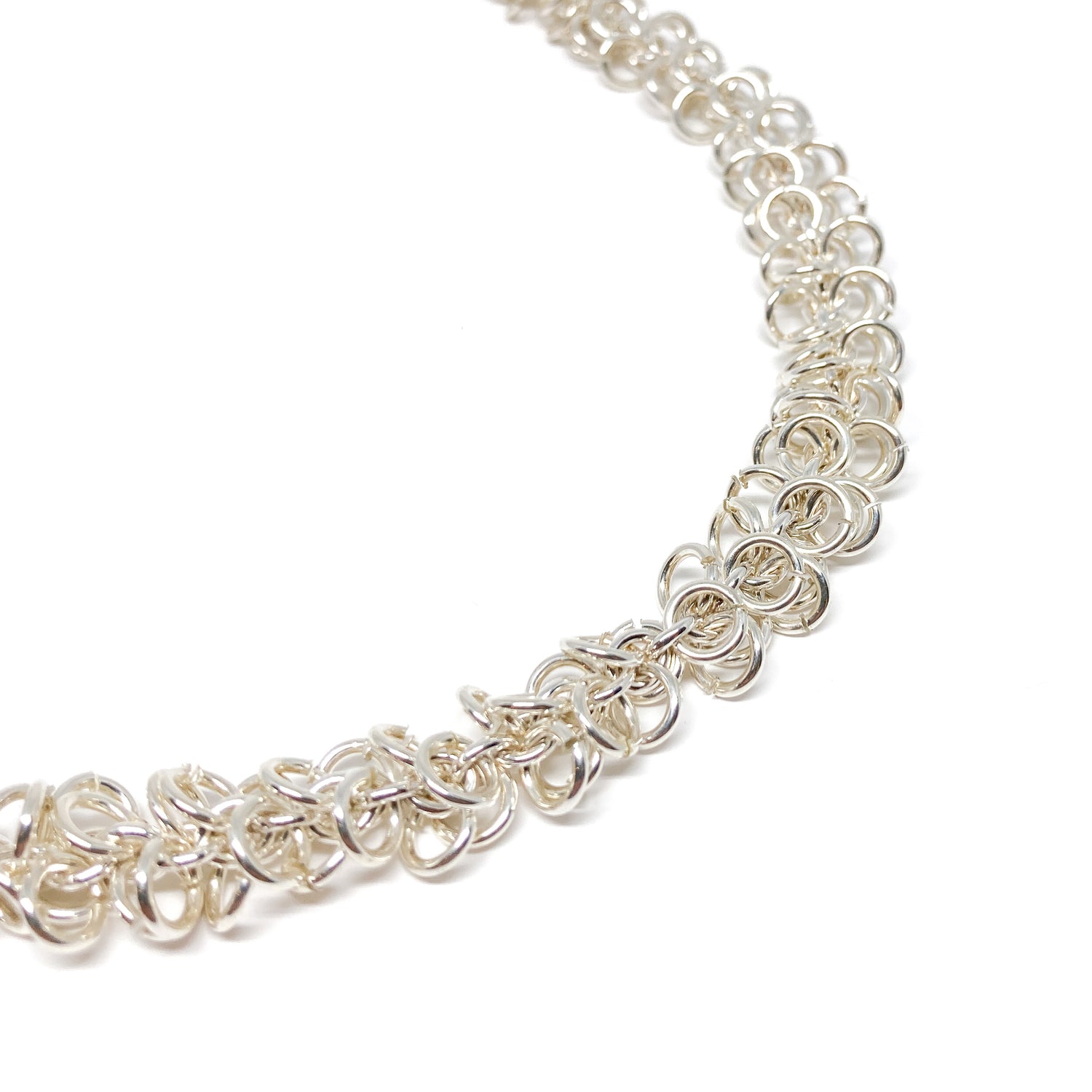 Close-up of a silver Falling Link Necklace, highlighting its delicate, interwoven circular links.