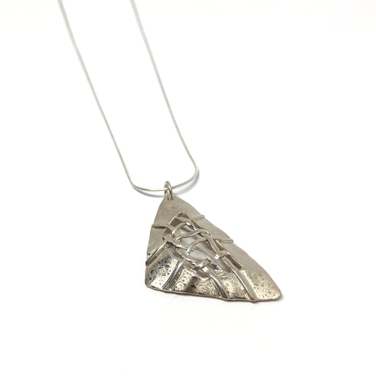 A silver pendant necklace with a triangular design and woven silver details. The pendant hangs from a delicate silver chain.