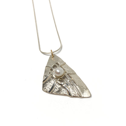 A silver pendant necklace with a triangular design, woven silver details, and a pearl accent. The pendant hangs from a delicate silver chain.