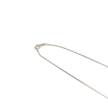 A close-up of a silver necklace clasp and chain. The delicate chain is thin and reflective.