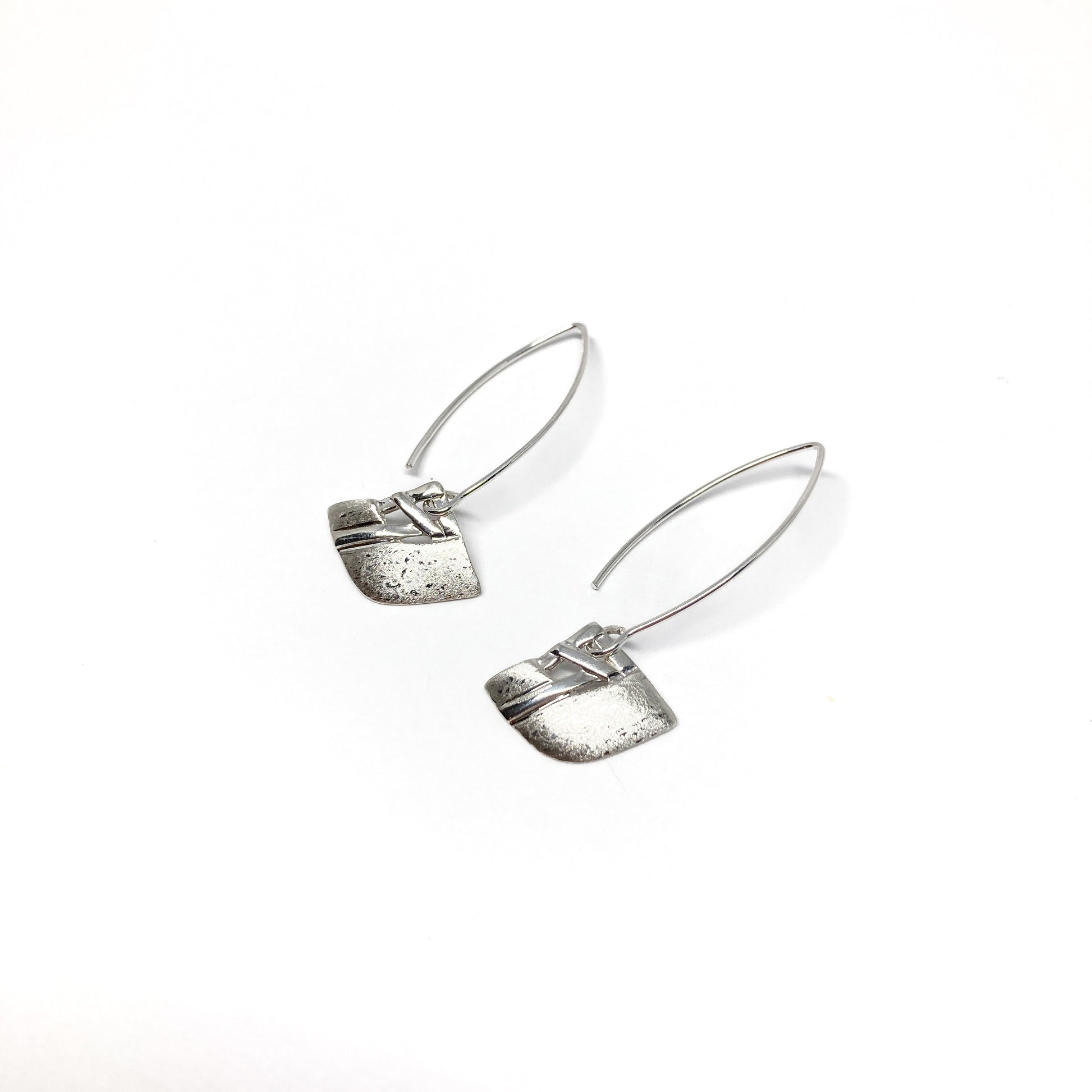 A pair of silver dangle earrings with a square woven design and a long, curved hook closure. The earrings have a textured finish.