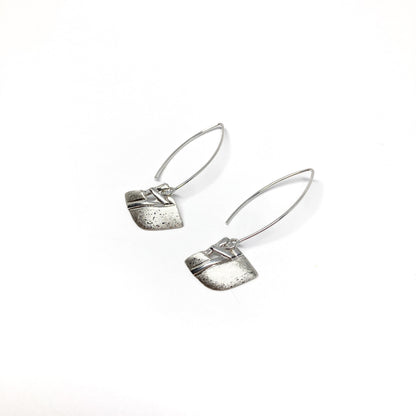 A pair of silver dangle earrings with a square woven design and a long, curved hook closure. The earrings have a textured finish.