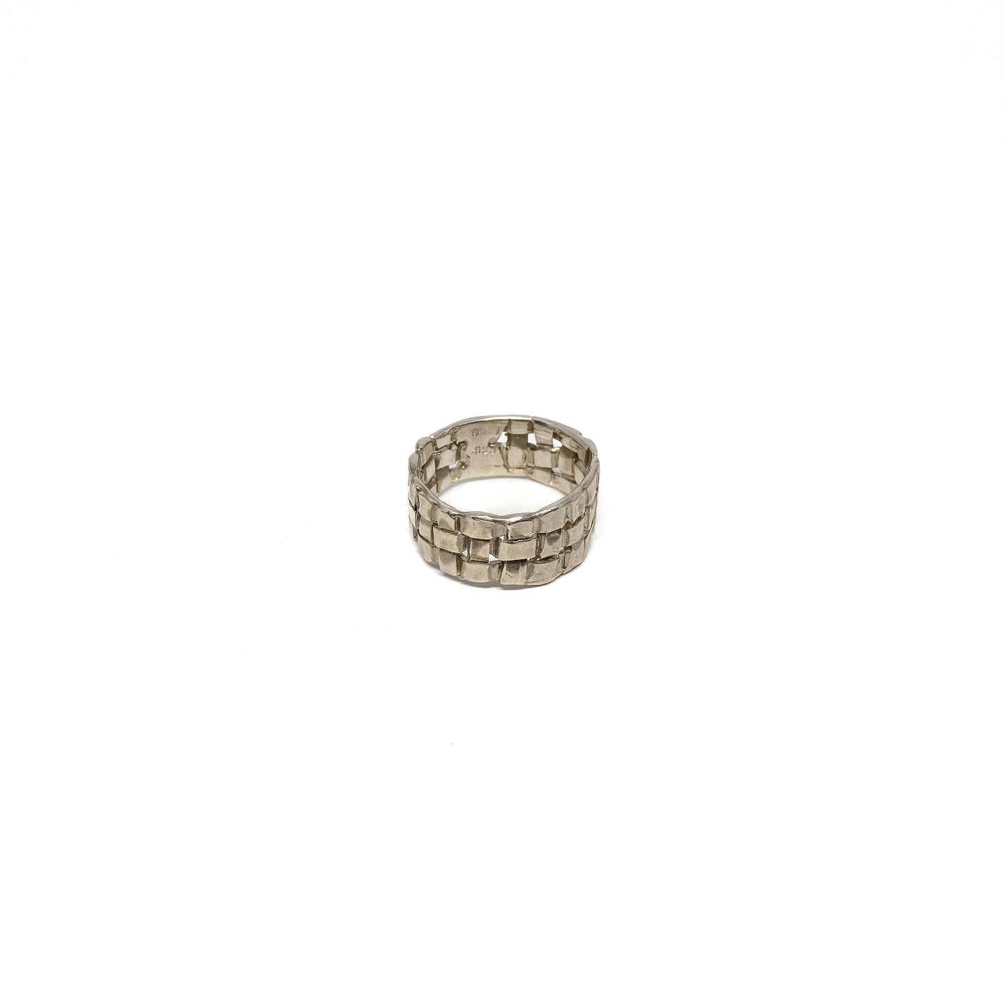 A chunky silver ring with a woven basket design. The ring has a wide band and a textured finish.