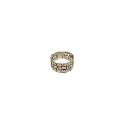 A chunky silver ring with a woven basket design. The ring has a wide band and a textured finish.