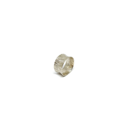 A wide sterling silver band ring with a deeply etched, flowing abstract pattern.