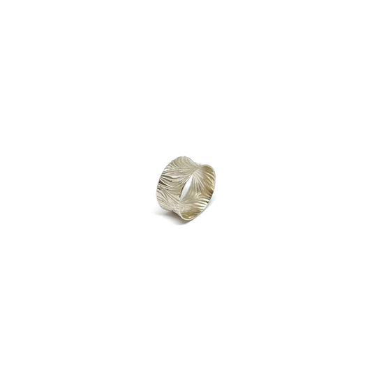 A wide sterling silver band ring with a deeply etched, flowing abstract pattern.