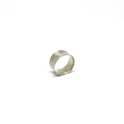Textured sterling silver cuff ring with a wide band and an etched, flowing abstract design.