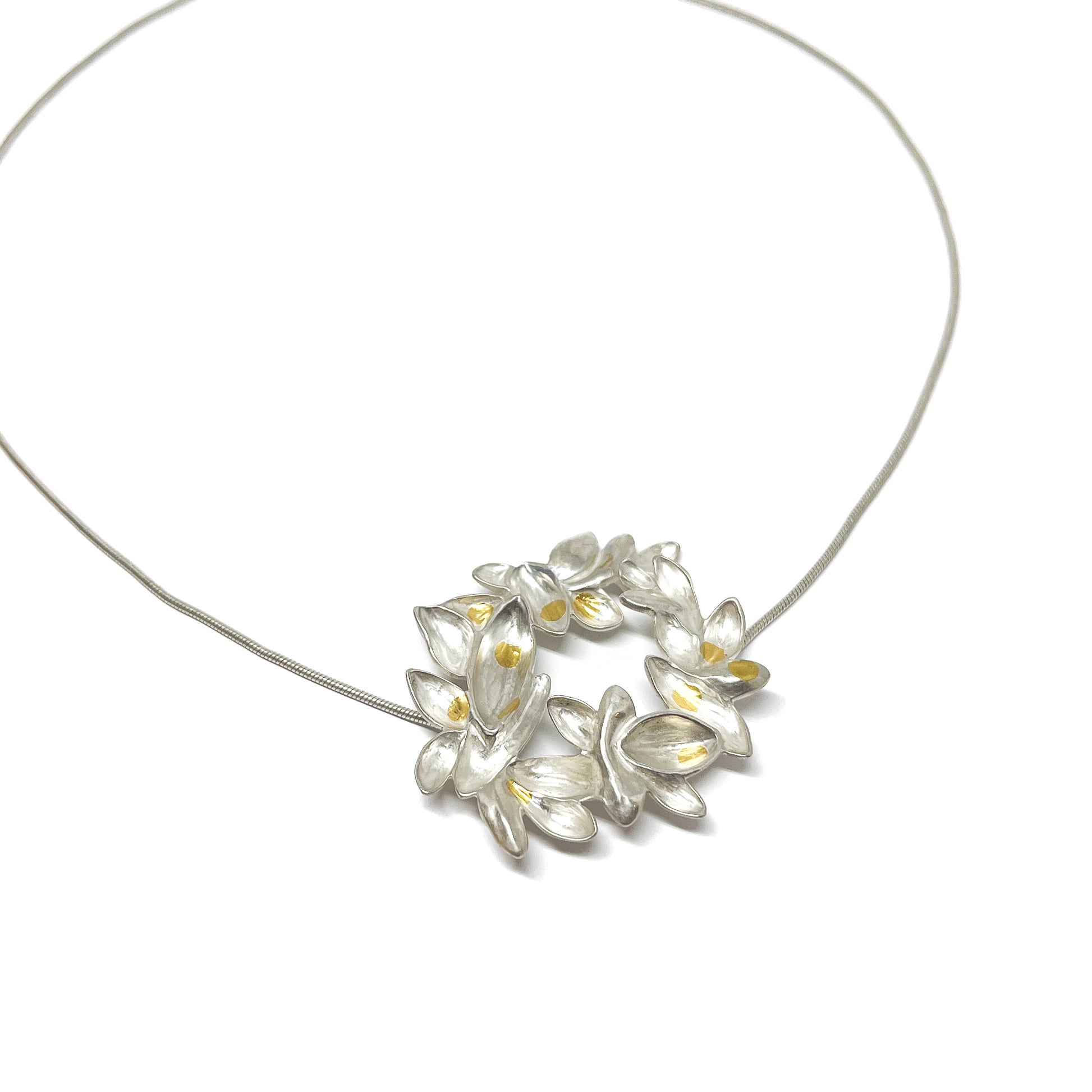 Silver snake chain necklace with a circular pendant of textured, abstract lily-like shapes and Keum-Boo gold accents.