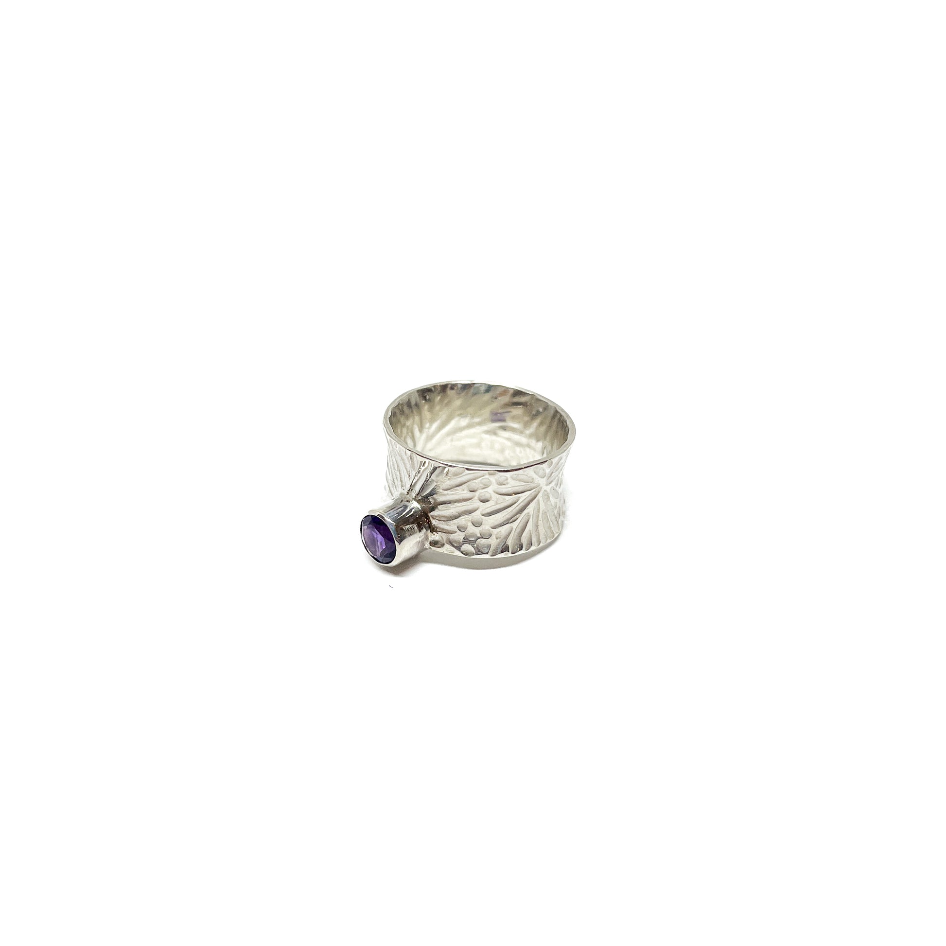 Textured sterling silver spinner ring featuring a single, oval-cut amethyst gemstone.