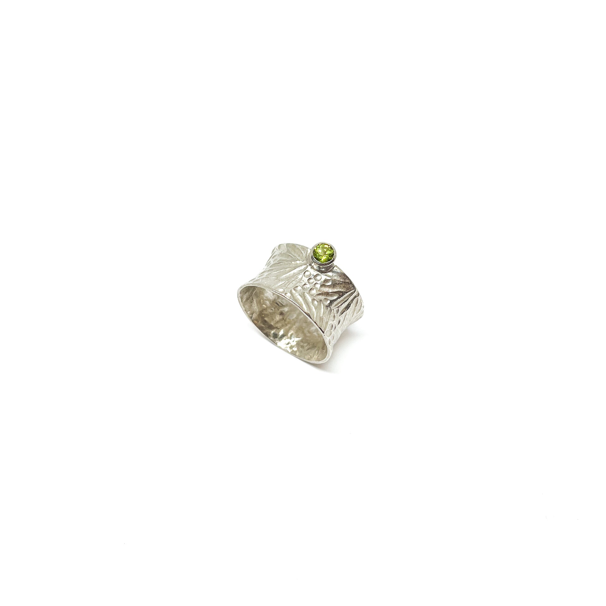 Textured sterling silver spinner ring featuring a single, round peridot gemstone.