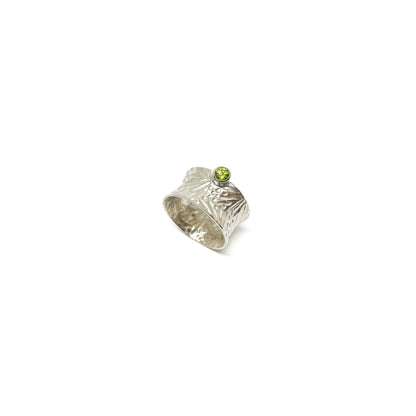 Textured sterling silver spinner ring featuring a single, round peridot gemstone.