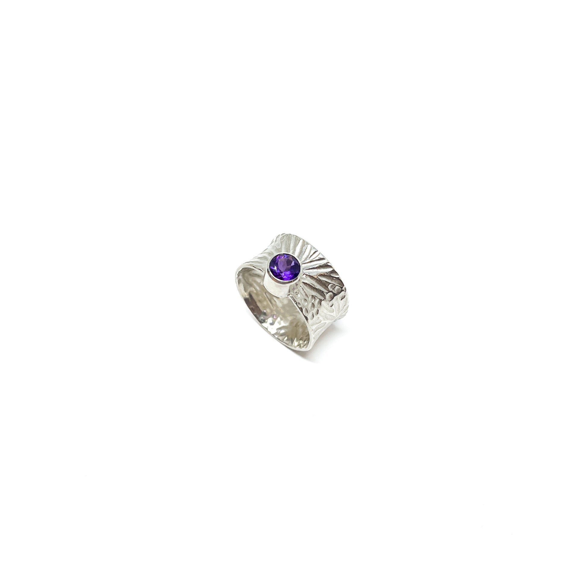 Textured sterling silver spinner ring featuring a single, round amethyst gemstone.