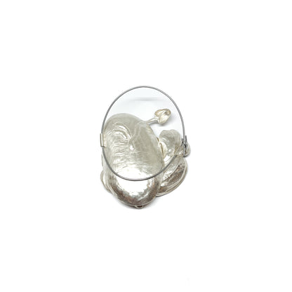A large, textured silver brooch featuring abstract, organic shapes resembling stylized leaves or petals and a circular wire frame.
