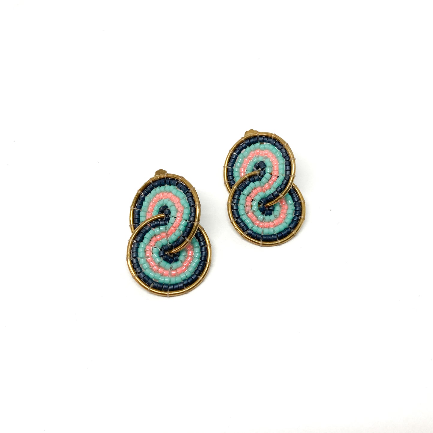 Two gold-toned clip-on earrings feature a figure-eight design intricately filled with pink, teal, and dark blue beads.