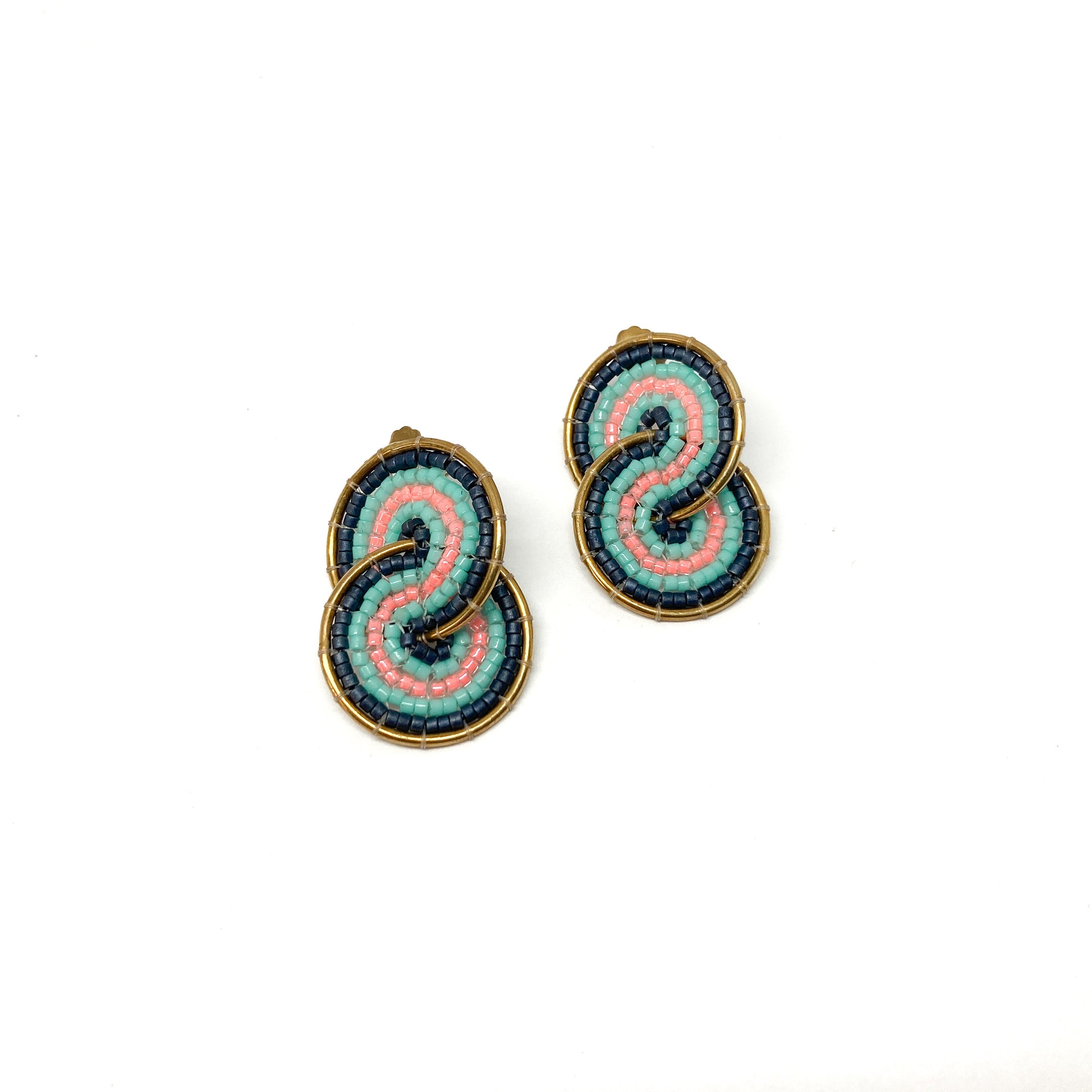 Two gold-toned clip-on earrings feature a figure-eight design intricately filled with pink, teal, and dark blue beads.