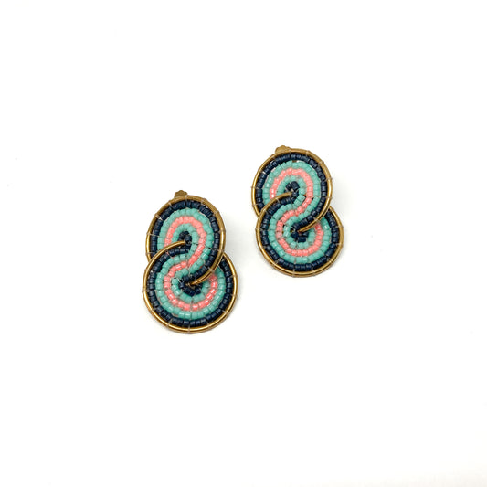Two gold-toned clip-on earrings feature a figure-eight design intricately filled with pink, teal, and dark blue beads.