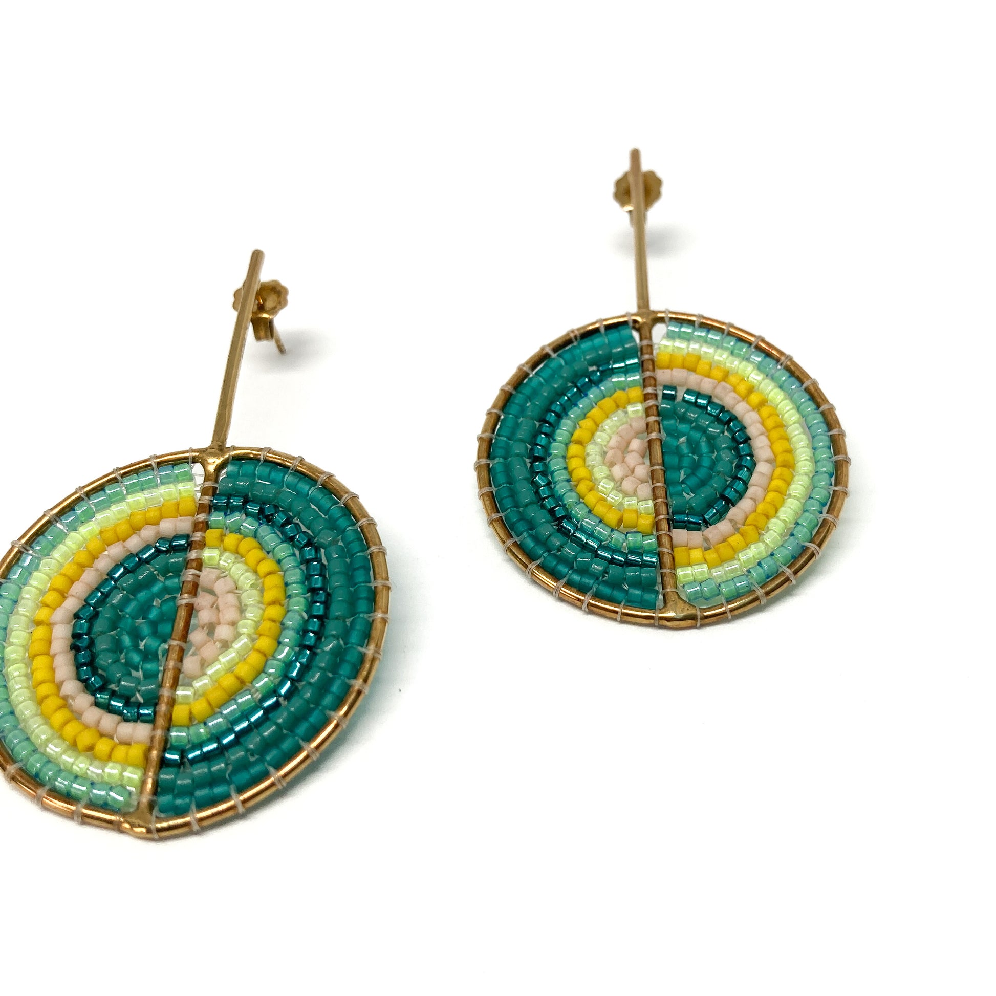 Two gold-toned stud earrings feature circular designs intricately filled with teal, yellow, light green, and pink beads.