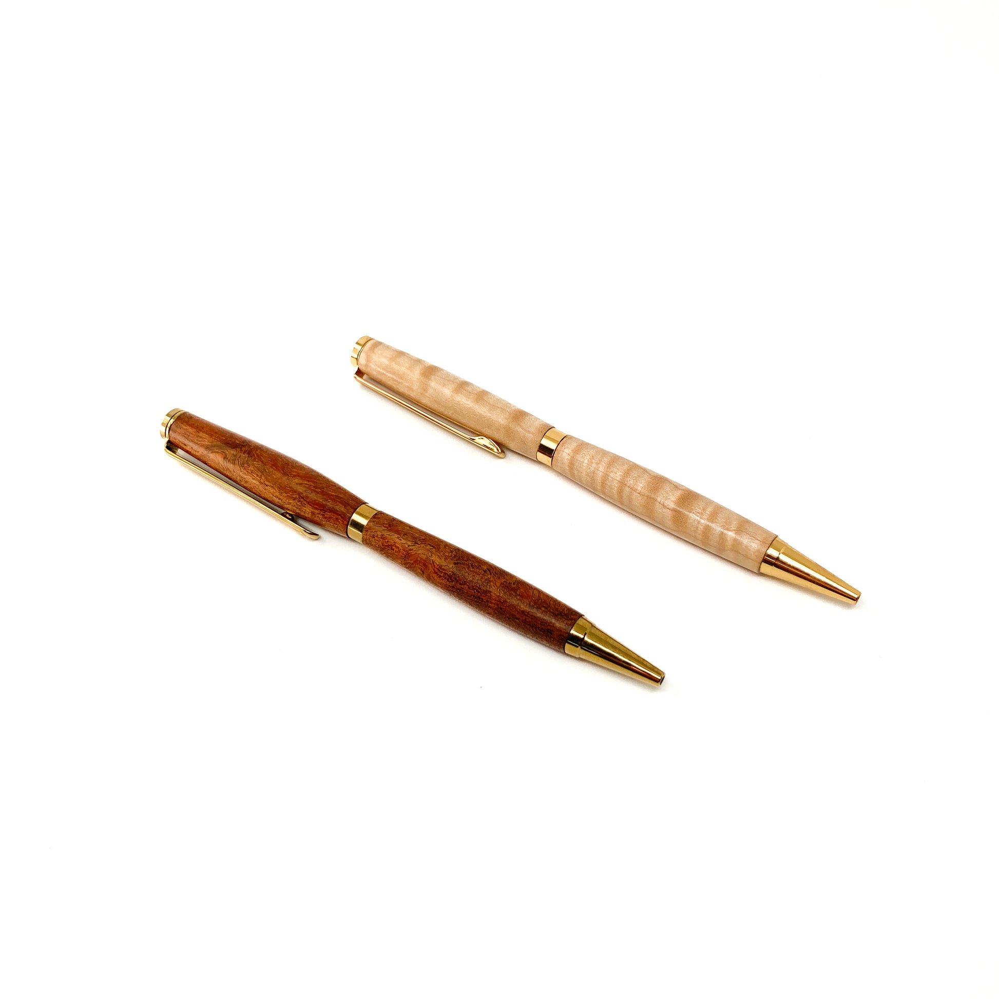 Two wood pens, one dark, one light, with gold trim, angled view.