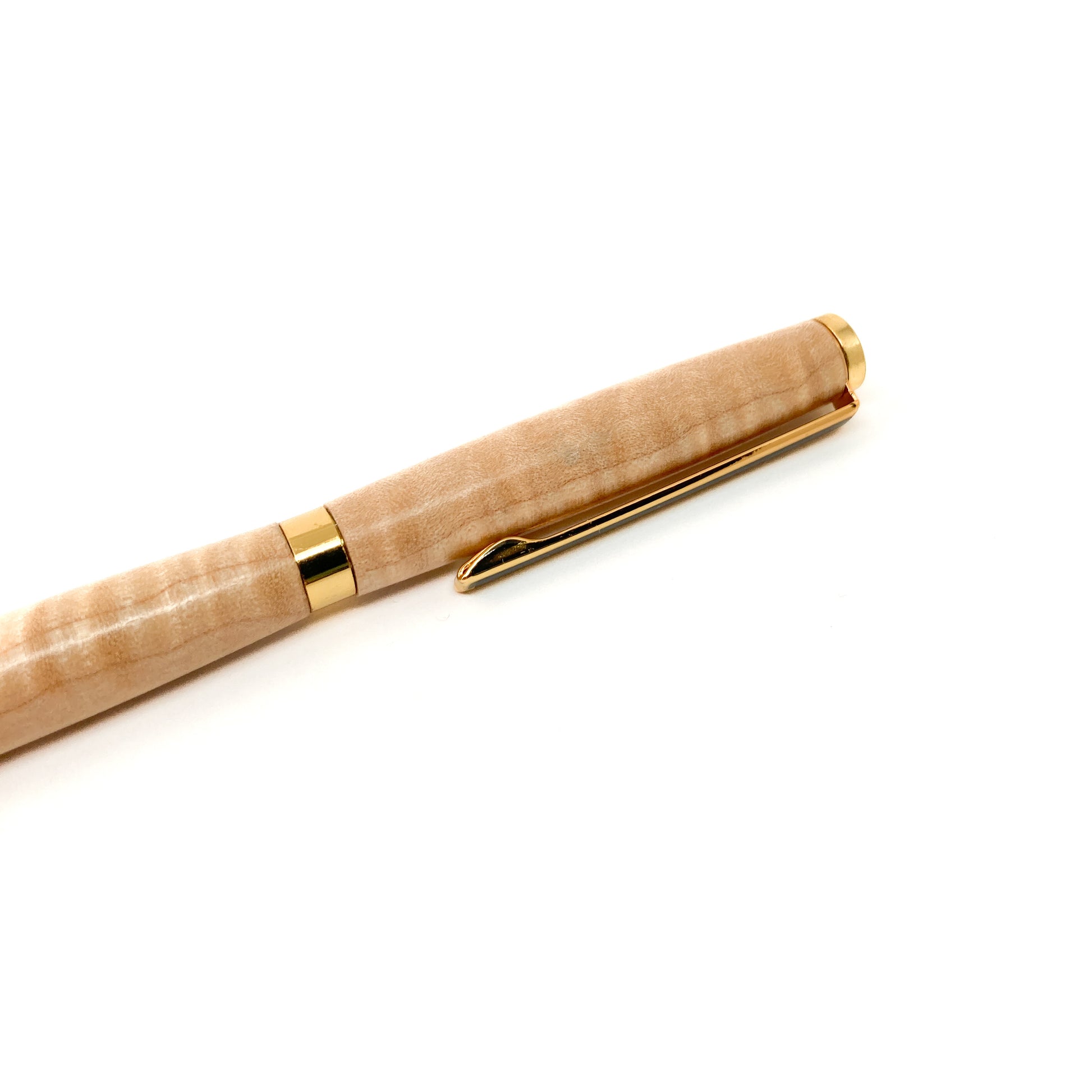 Light wood pen with gold trim and clip, close-up view.
