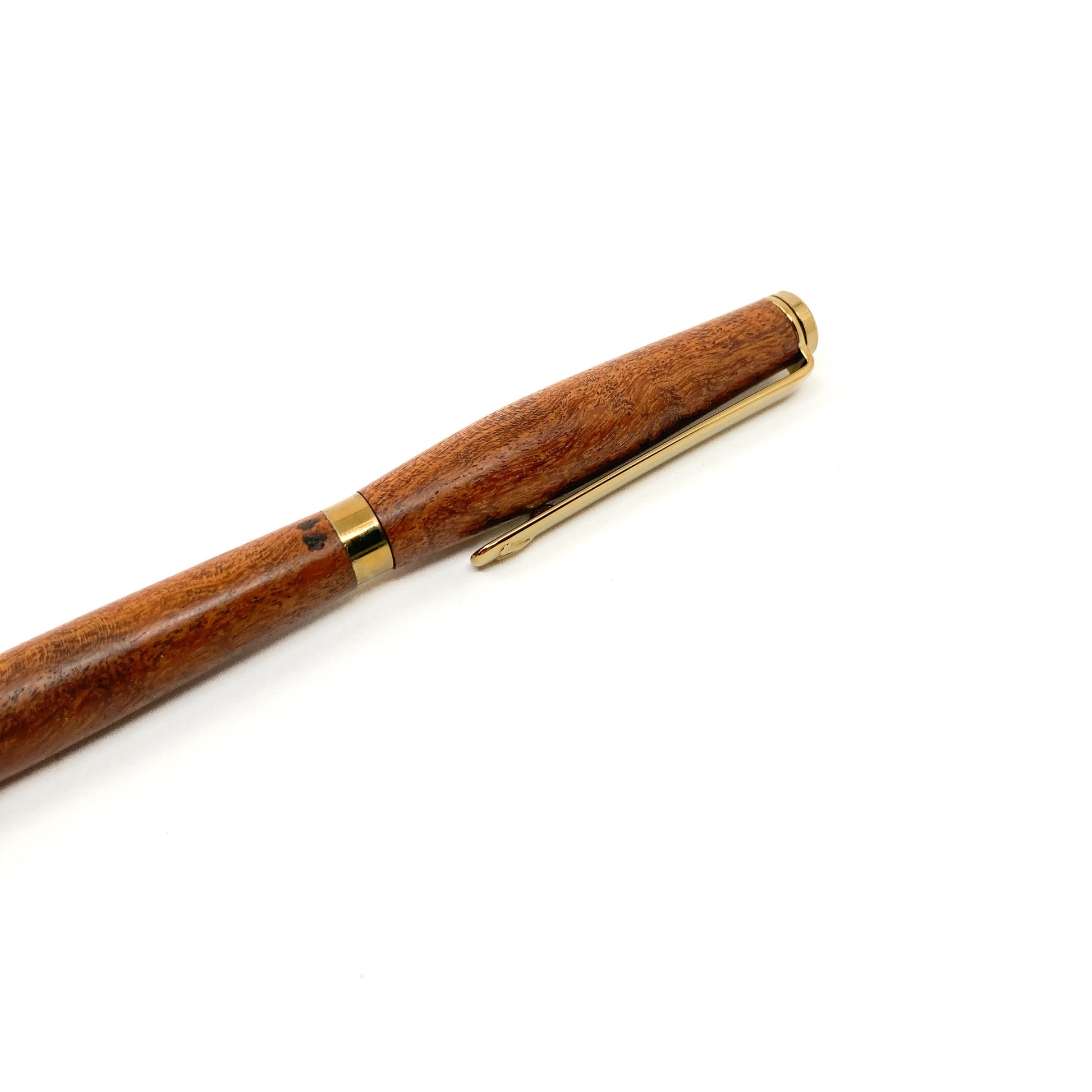 Dark wood pen with gold trim and clip, close-up view.