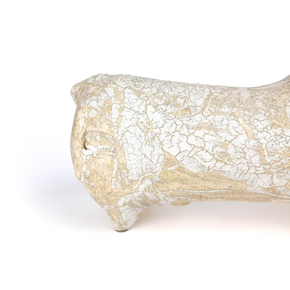 Partial view of a textured, light-toned ceramic bull figurine's rear with a raised tail and crackled glaze.