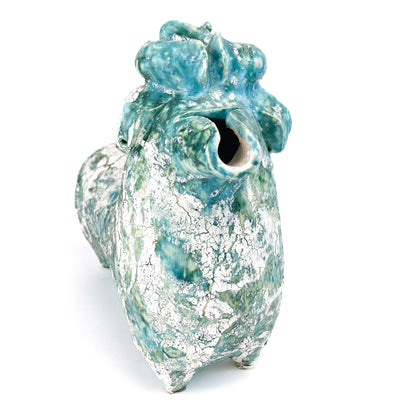 Textured ceramic bull figurine with a teal and white mottled glaze, facing forward with curled horns and a hollow snout.
