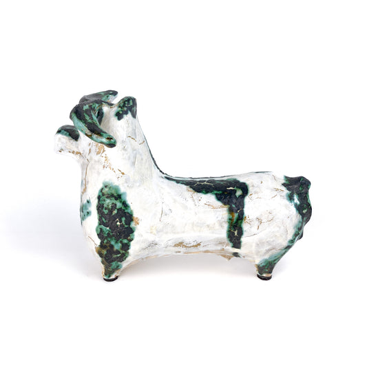 A textured ceramic bull figurine with a white base and mottled teal and black markings, featuring curled horns.