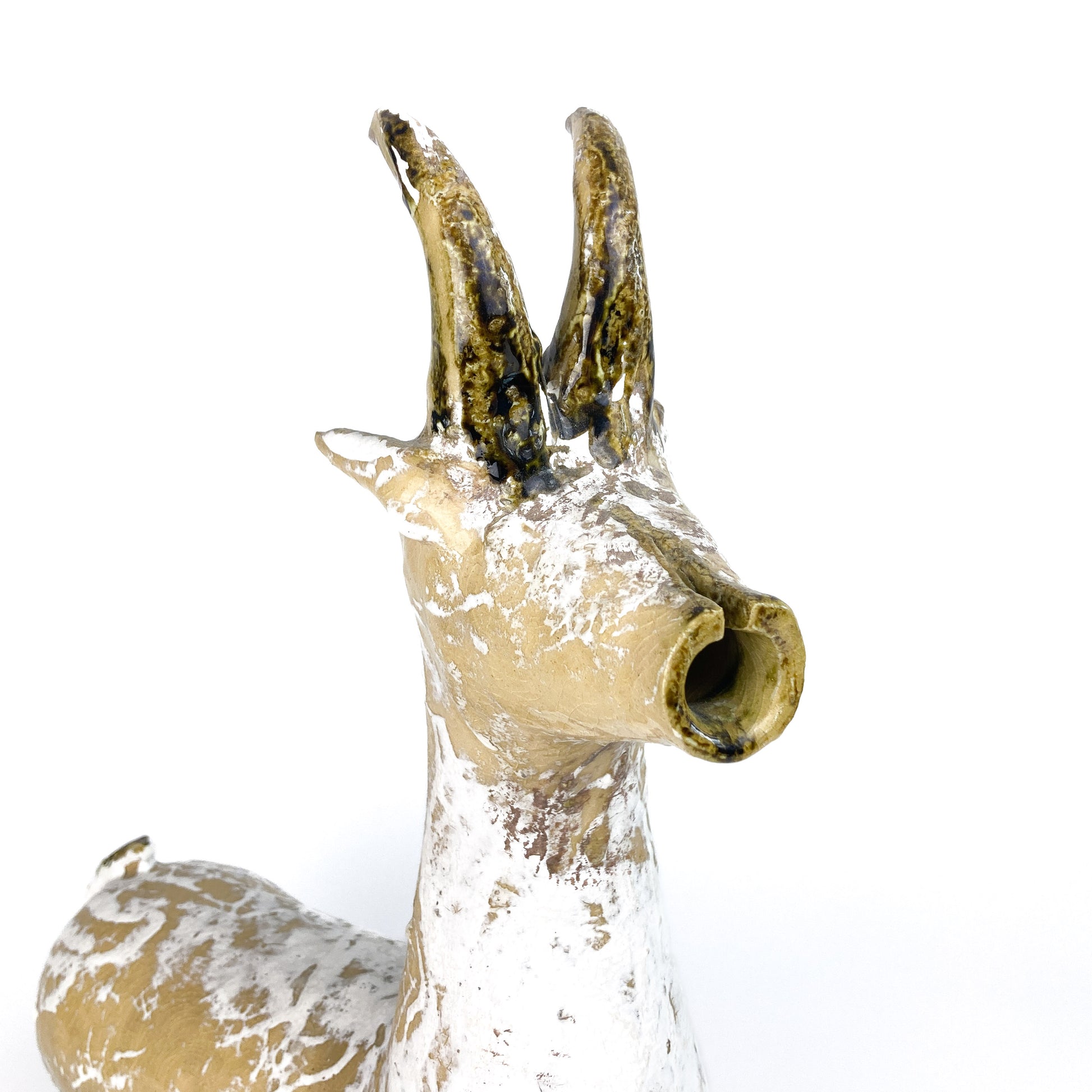 Close-up of a textured ceramic Long Neck Bull head with tall, curved horns and a distressed, light-toned glaze with white accents.
