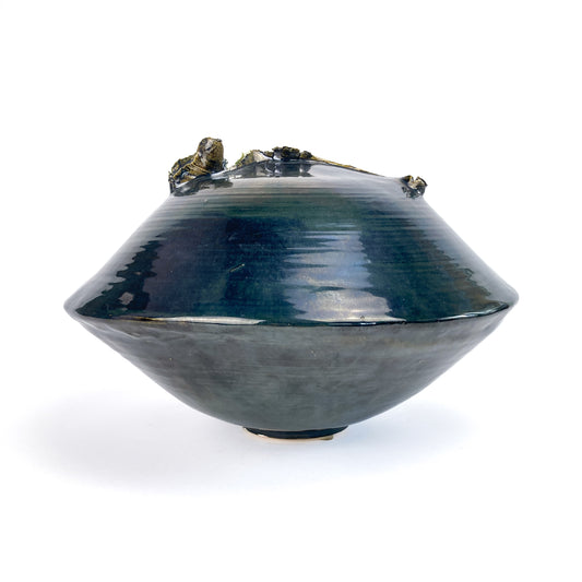 A dark, conical ceramic UFO sculpture with a textured, organic rim and a subtle gradient in its glaze.