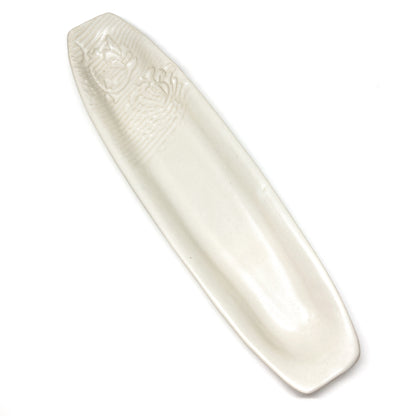A long, narrow, white olive dish with embossed details.