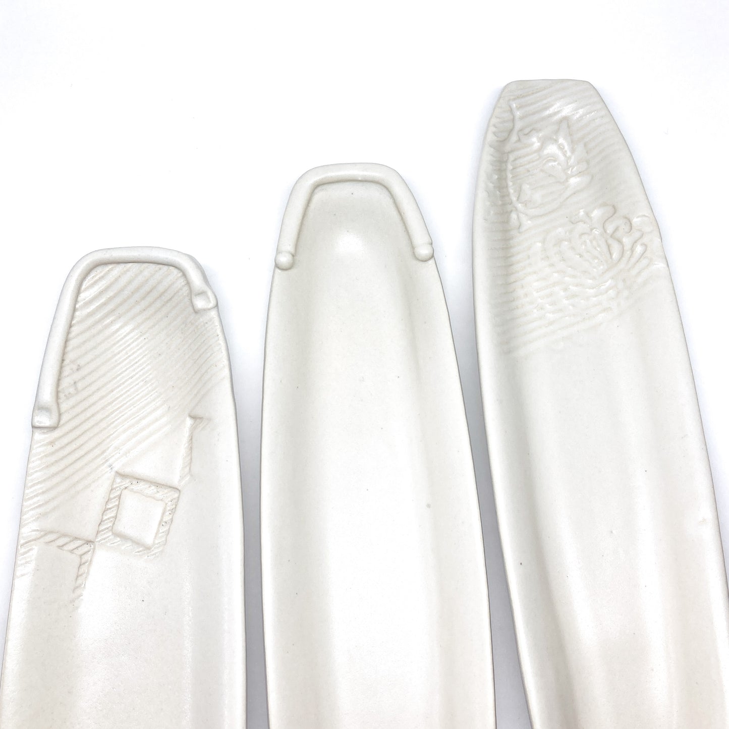 Three white olive dishes of varying styles.