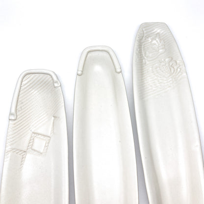 Three white olive dishes of varying styles.