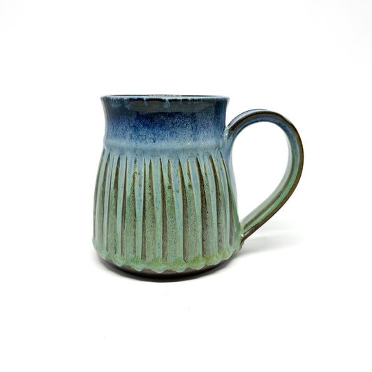 A ceramic mug with a ridged texture and a blue-to-green gradient.