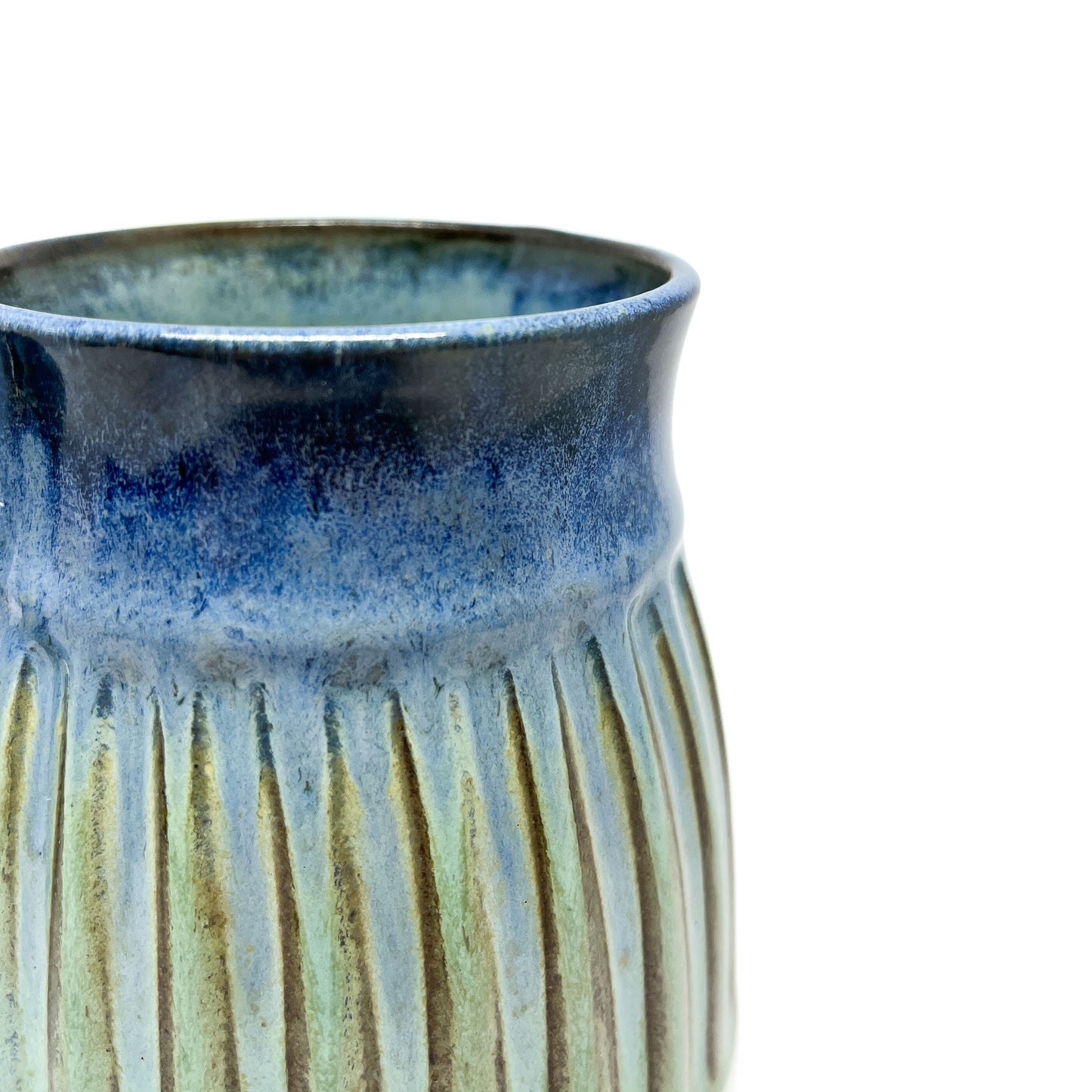 A close-up of a ceramic mug with a ridged texture and a blue-to-green gradient.