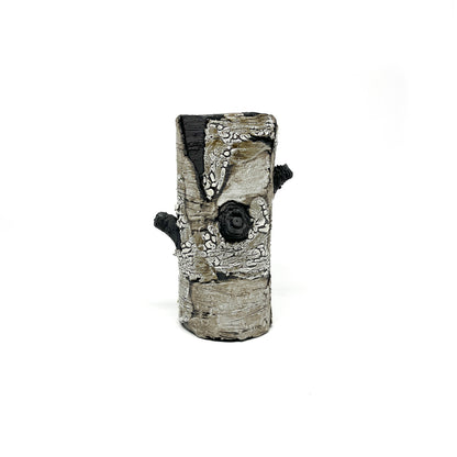 A cylindrical vase resembling birch bark with a textured surface, featuring black and white elements and two protruding branch-like details.