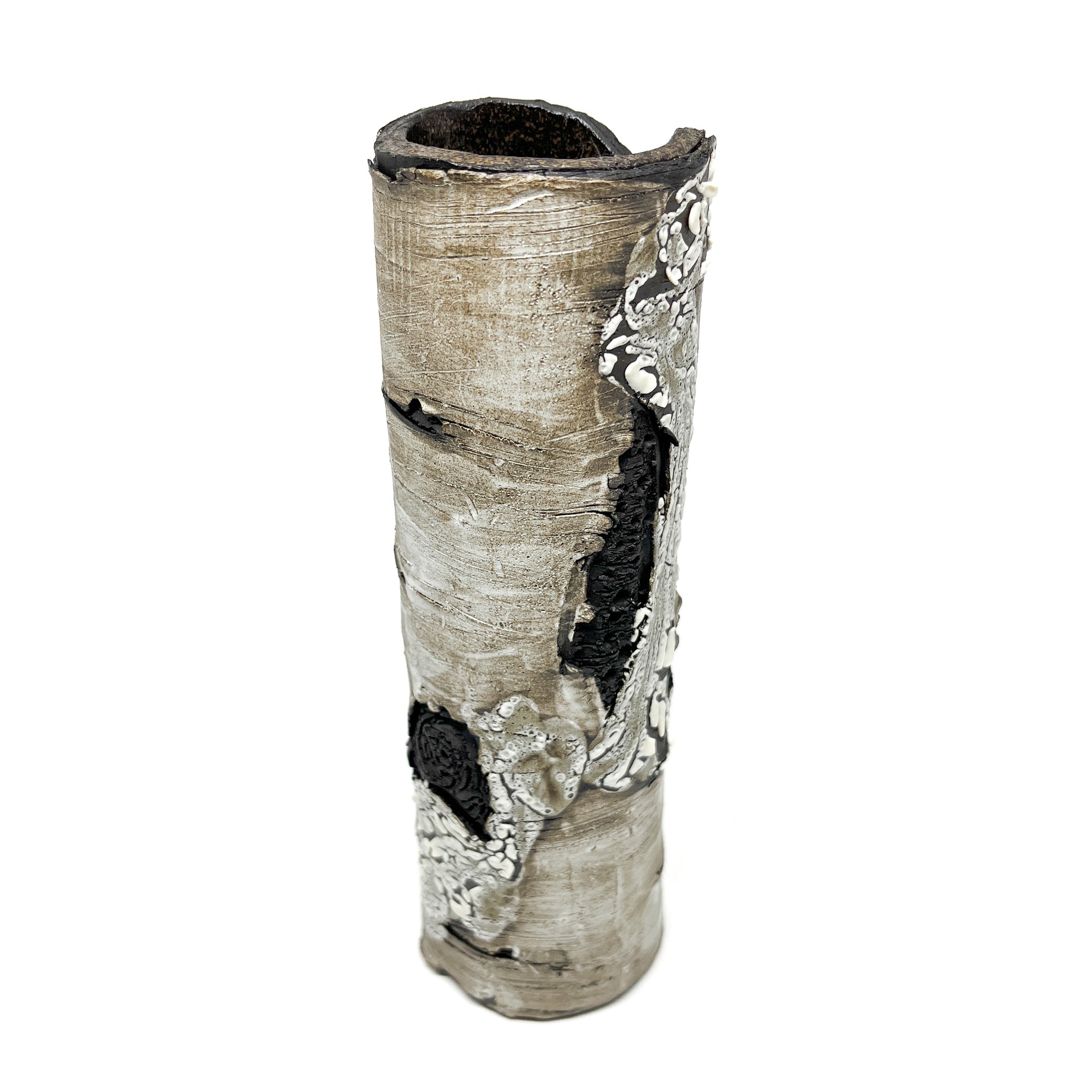 A tall, cylindrical vase resembling birch tree bark with a textured surface, featuring black and white elements.