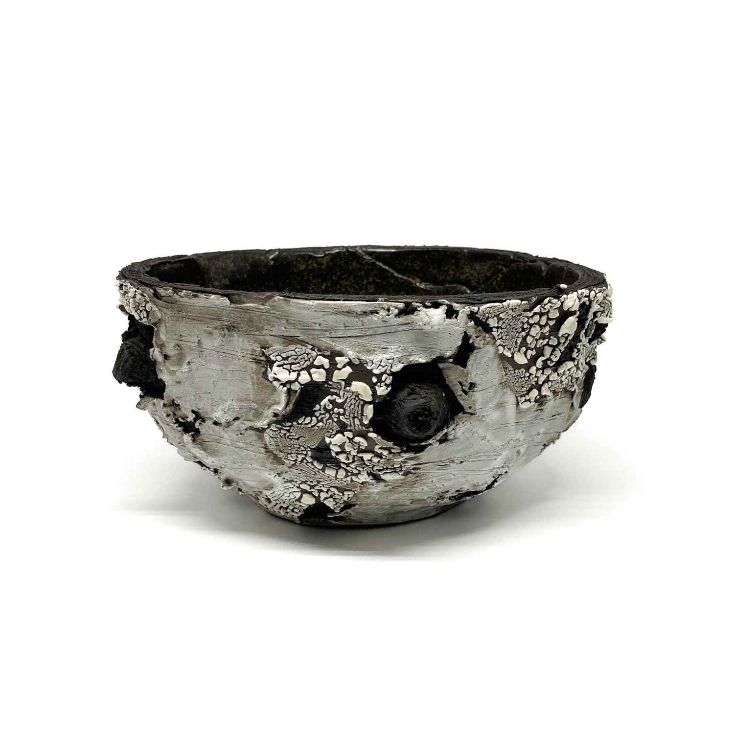 A small, round bowl with a textured surface, featuring black, white, and gray elements.