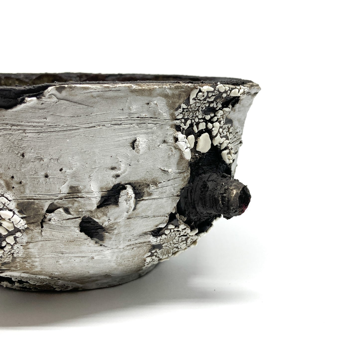 A close-up view of a small bowl with a textured surface and a protruding element.