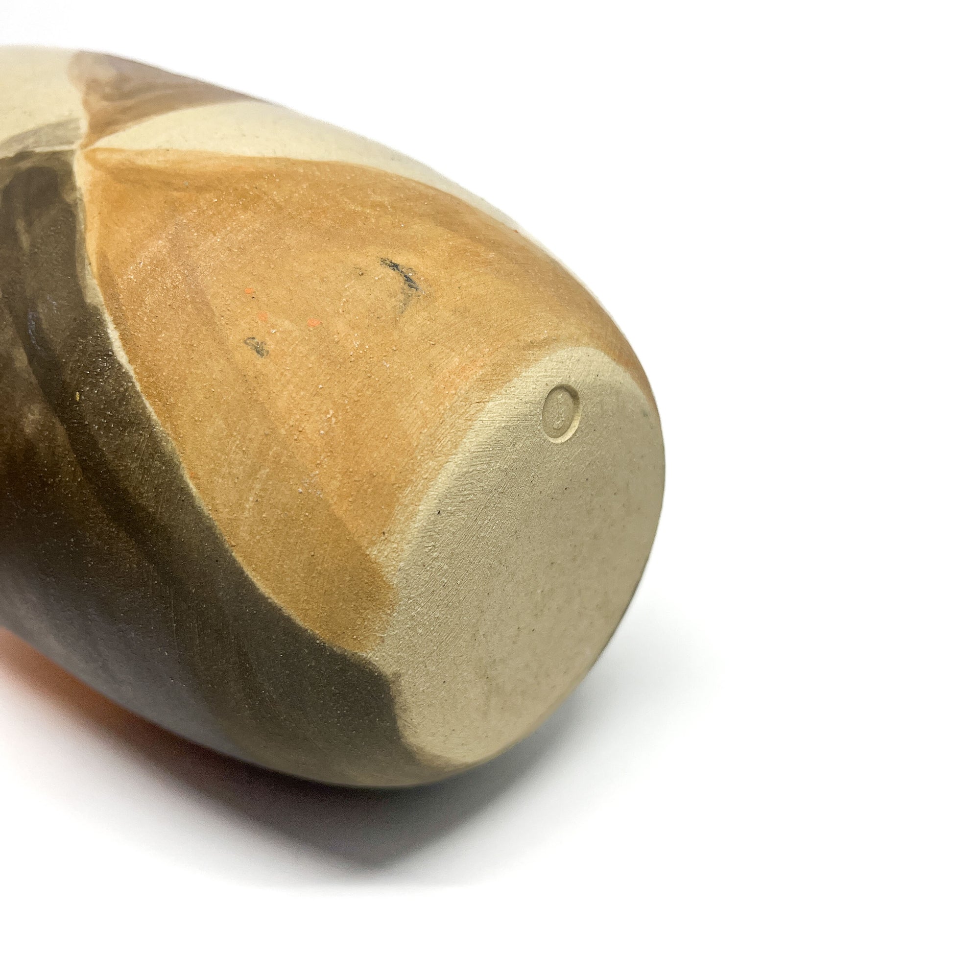 Bottom view of a vase showing its unglazed base and the organic flow of the naturally fired patterns.