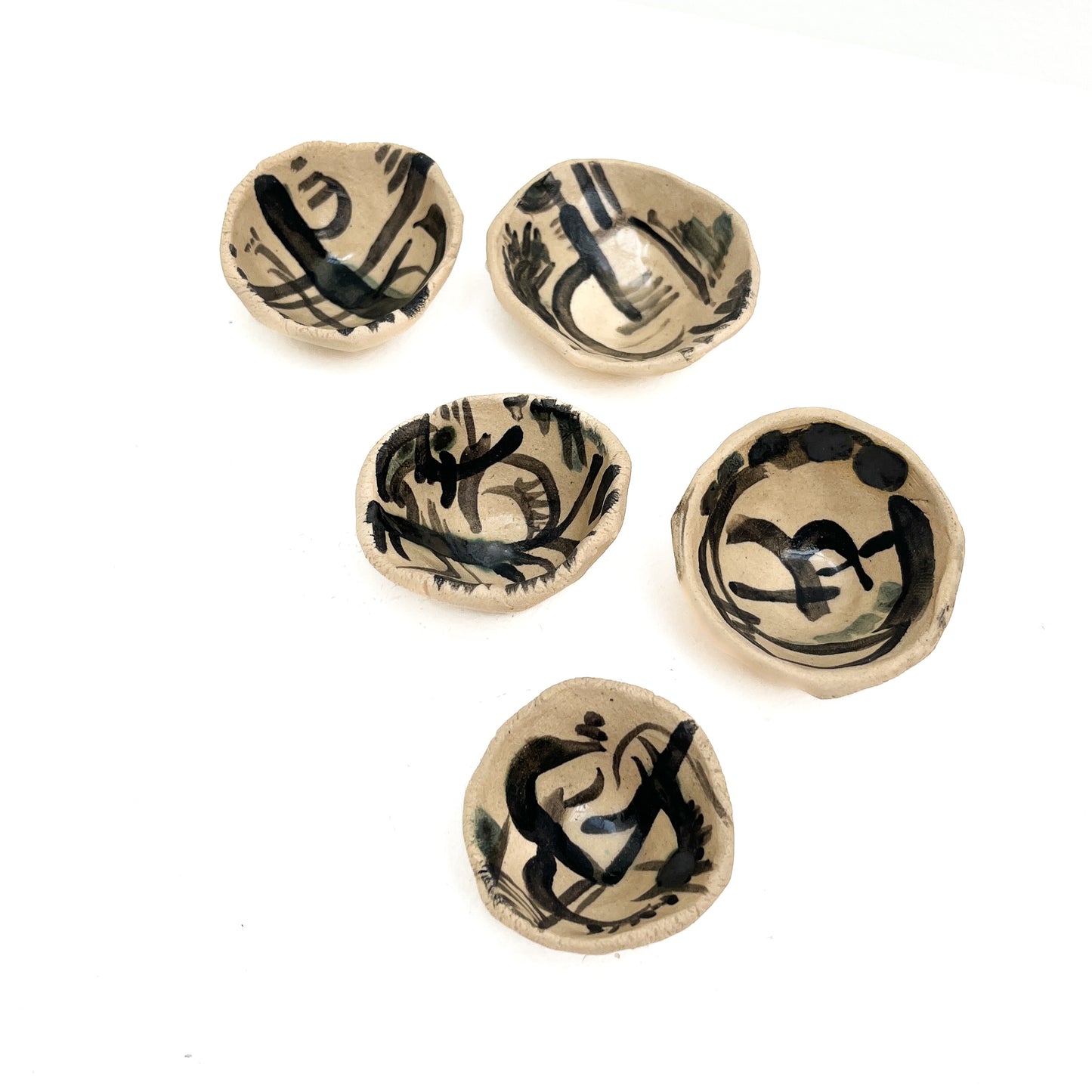 Five Kana London pinch pots with unique black abstract designs on a light base.